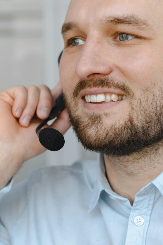 a man is smiling while using a black cordless headset