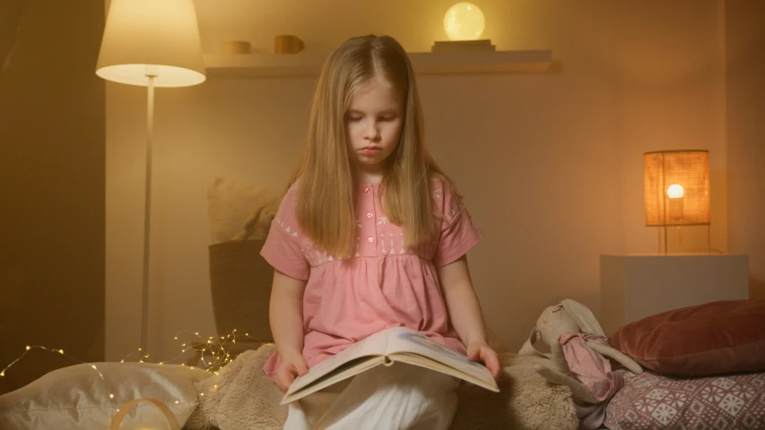 the girl is sitting on a couch reading