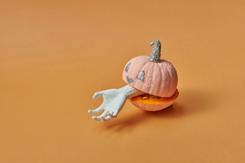 a toy pumpkin with an upside down white skeleton