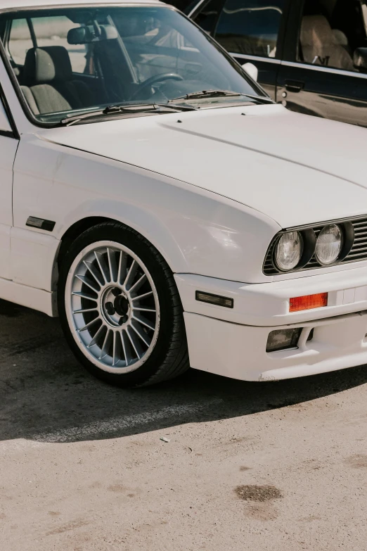 an old white car parked in a parking lot