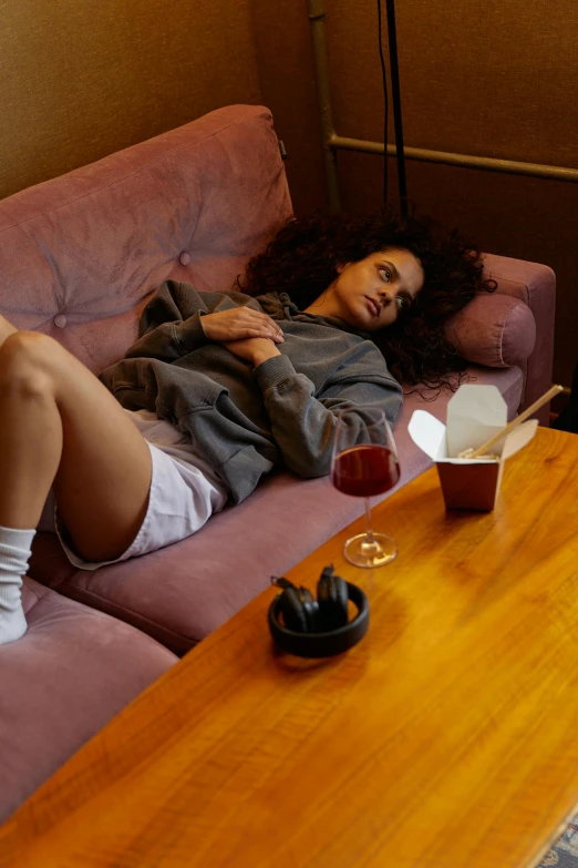 a woman sleeping on a couch with some beverages