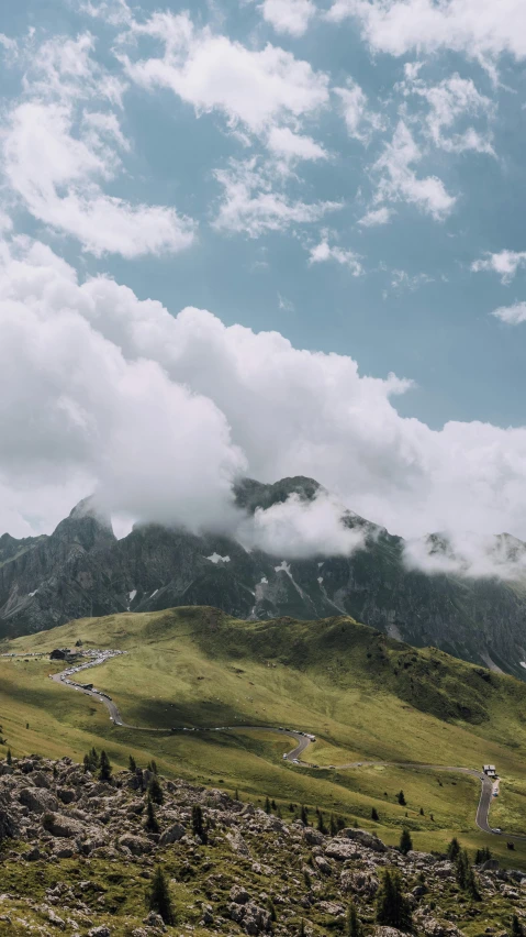 there is a mountain range under a blue cloudy sky