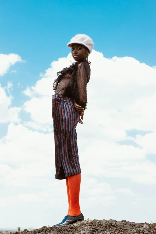 a woman standing on top of a dirt mound