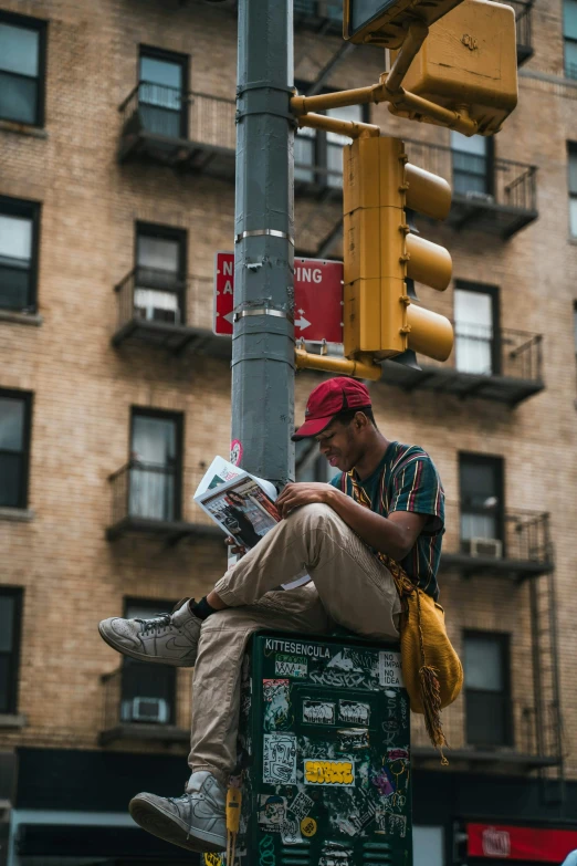 there is a man that is sitting on top of a pole