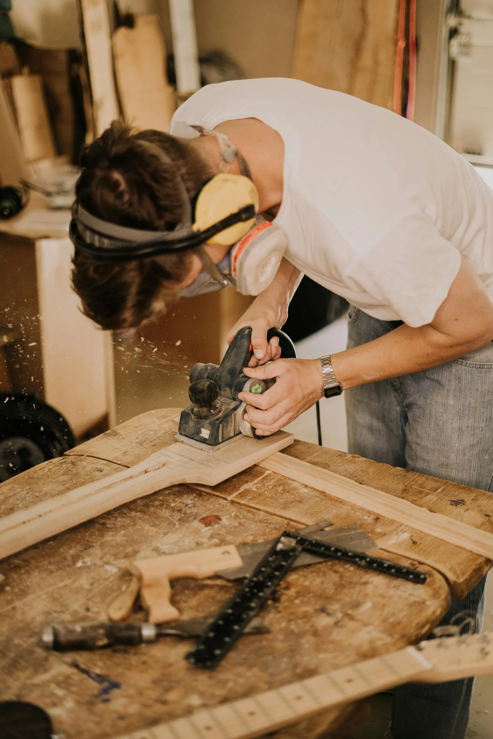 a man is sanding on a board working on wood