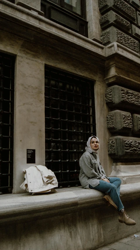 a woman is sitting outside of an old building