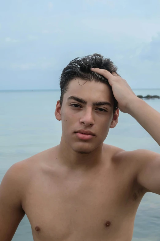 a young man stands in the water while posing for a picture