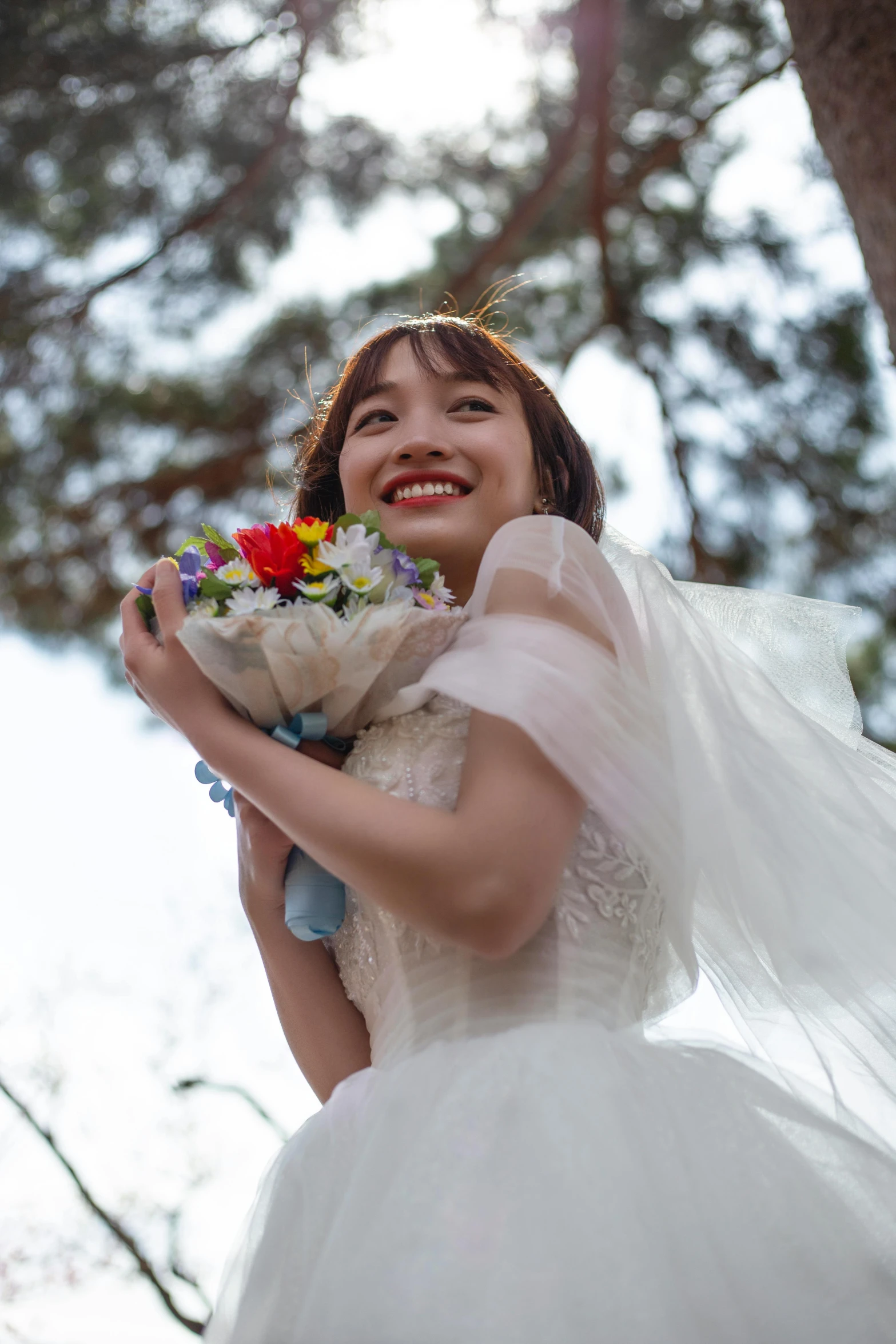 a woman is smiling as she carries flowers