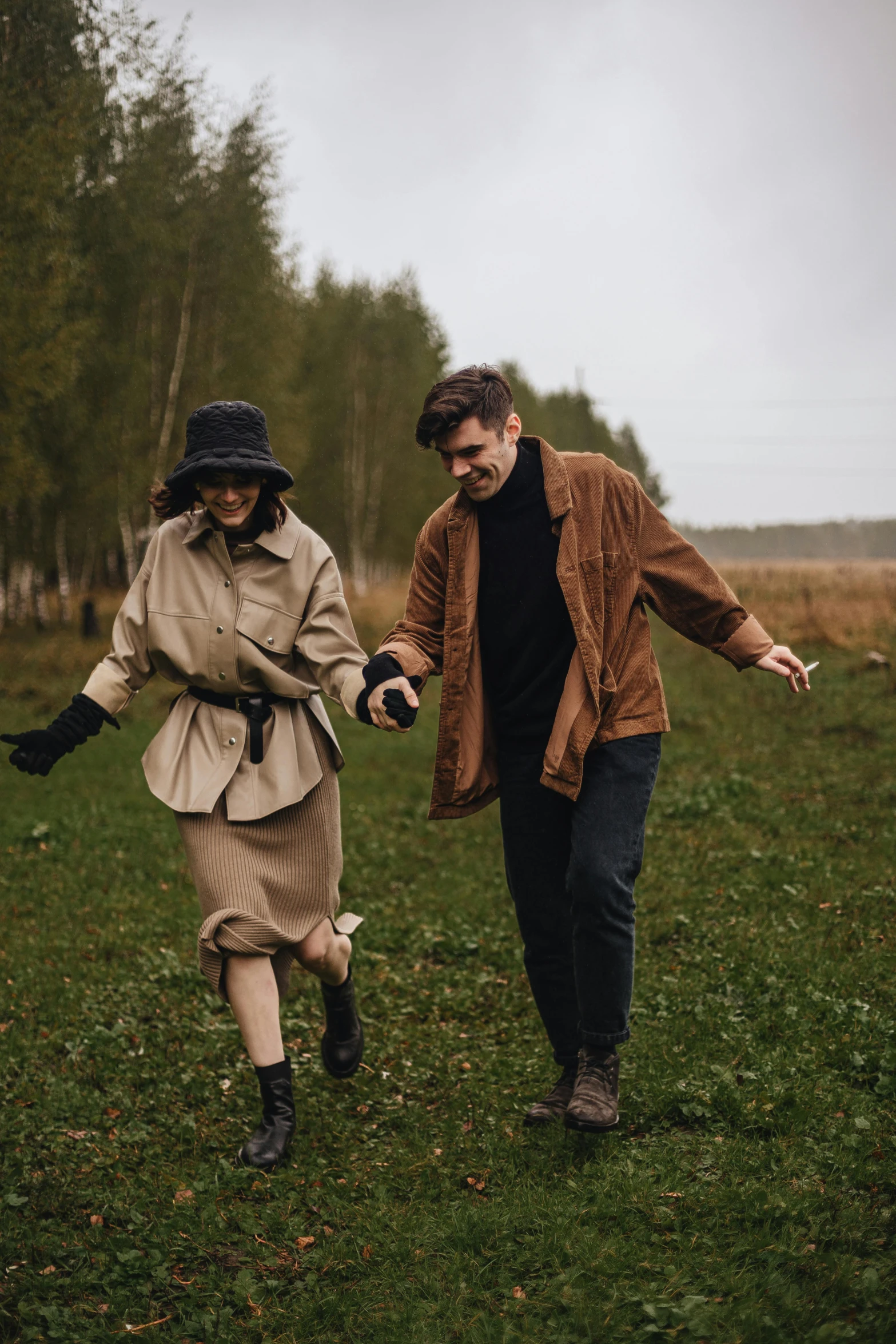 two people walking in the grass while one is holding hands