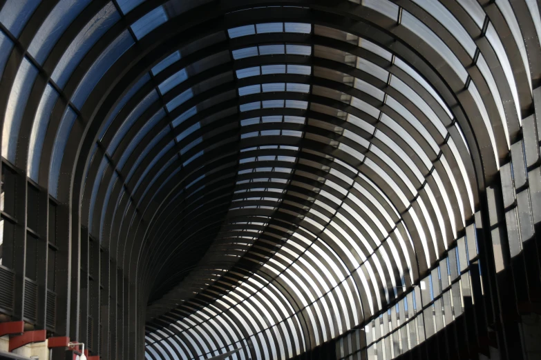 curved walkway with several sets of glass and steel screens