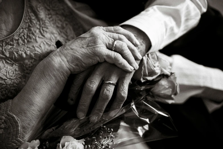 two old hands holding each other as they hold hands