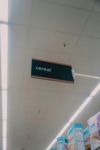 a black sign hangs over the back wall of a grocery store