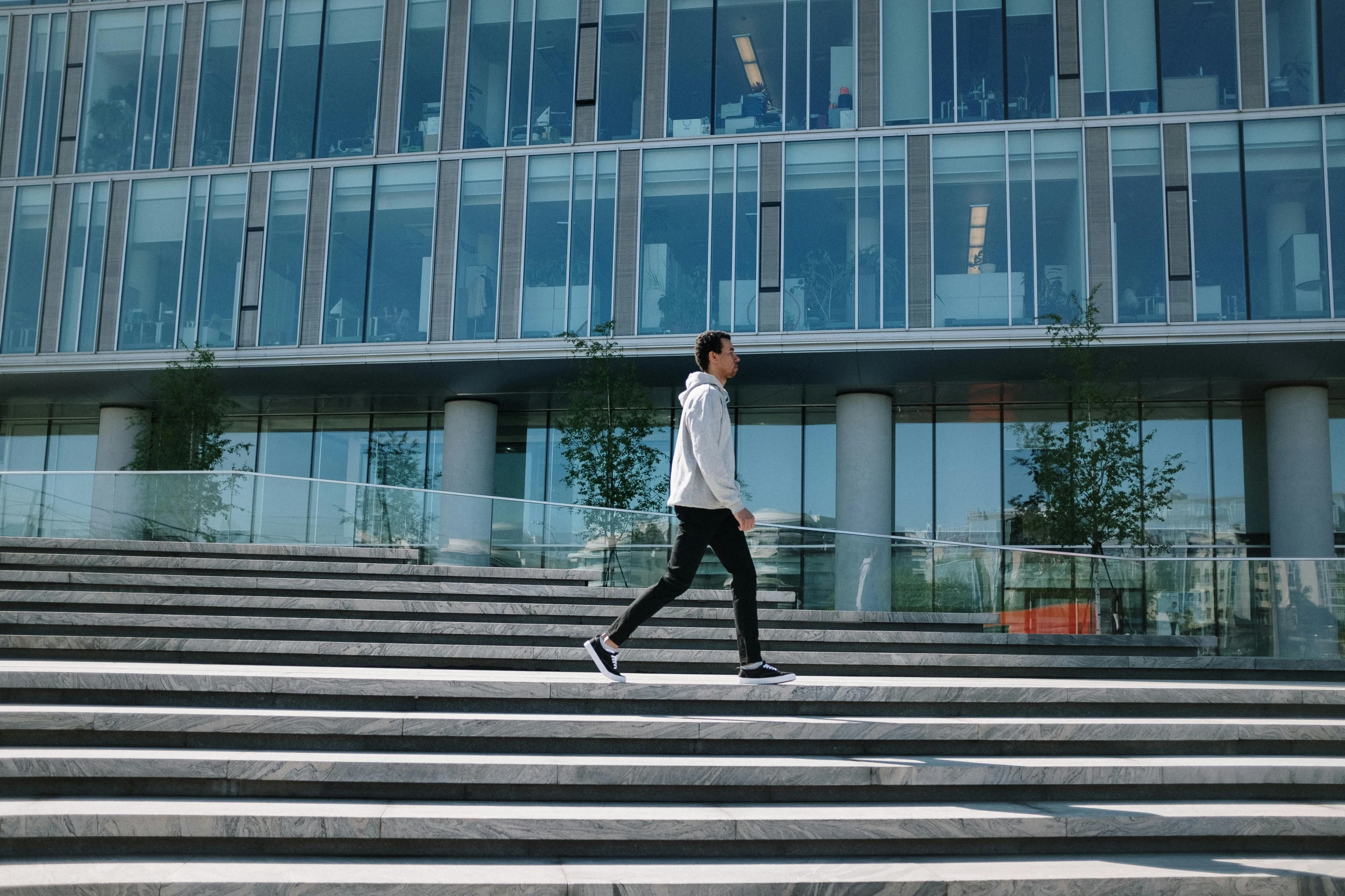 a young woman walking up a stairway towards a very tall building