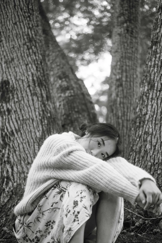 a woman in a skirt is sitting on a tree