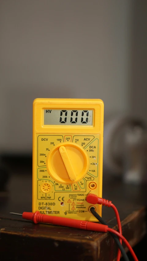 an electrical meter sitting on top of a wooden table