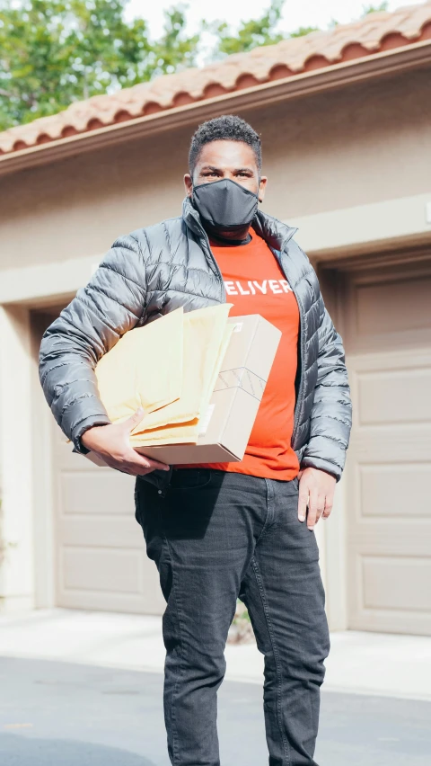 a man holding an envelope and wearing a mask