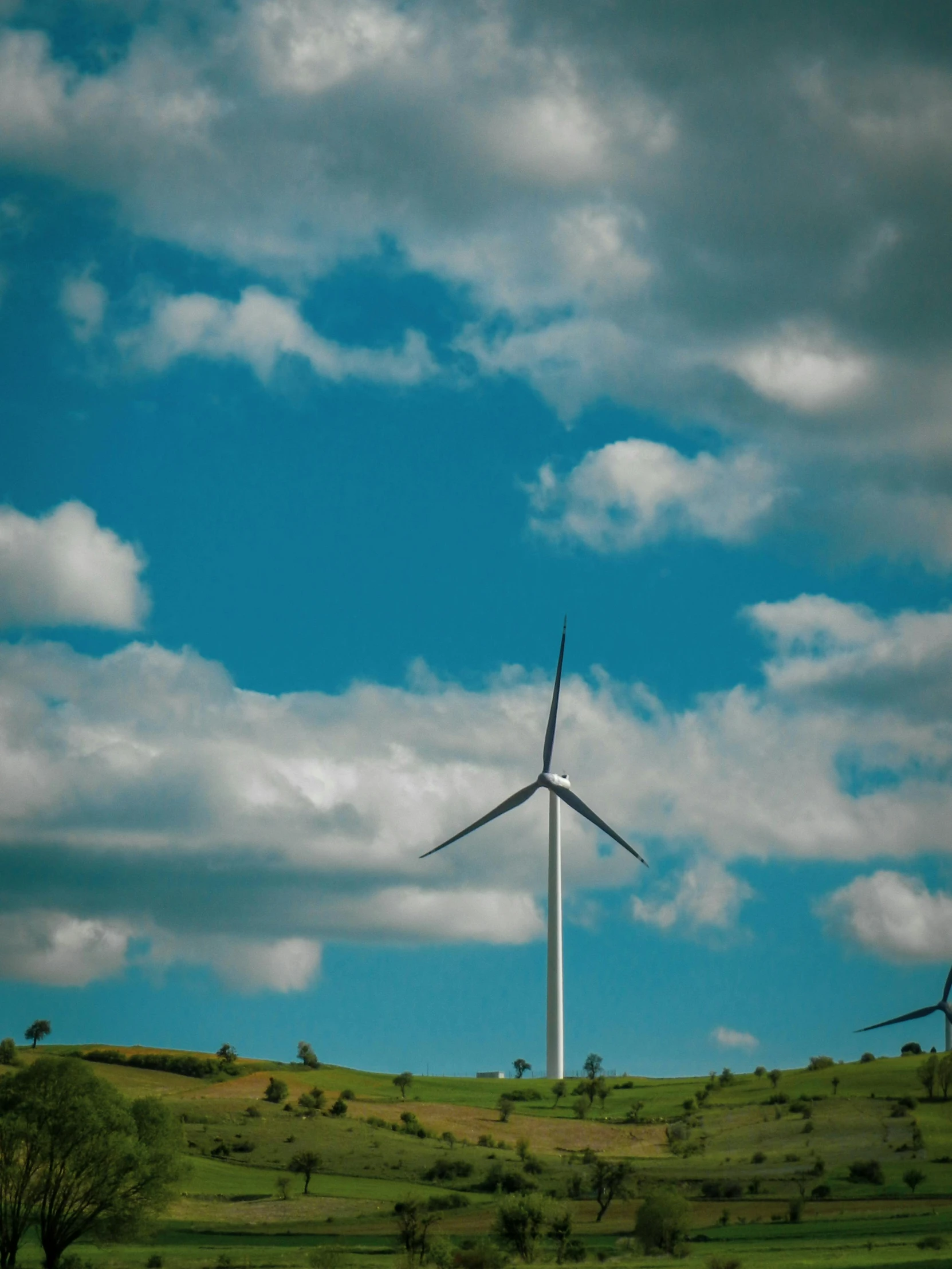 a windmill is standing out in the open on a sunny day