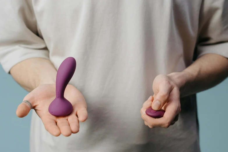 person holding two fingers with purple handle next to each other
