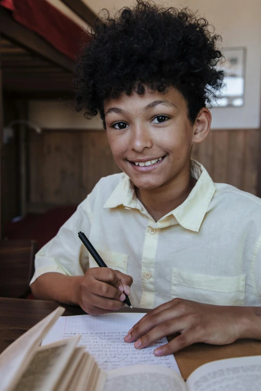a little boy is smiling while doing his homework