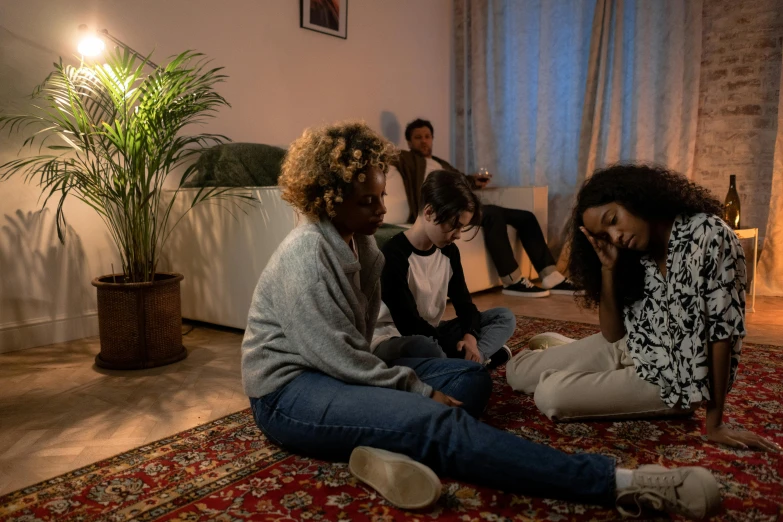 four women sitting on the floor in front of a mirror