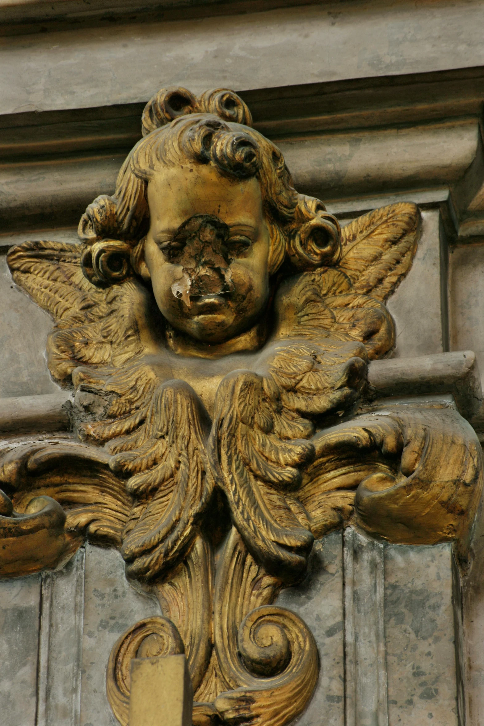 an antique statue has winged, elaborate ornaments on the outside of it