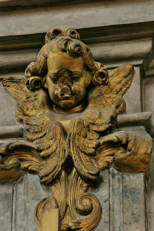 an antique statue has winged, elaborate ornaments on the outside of it