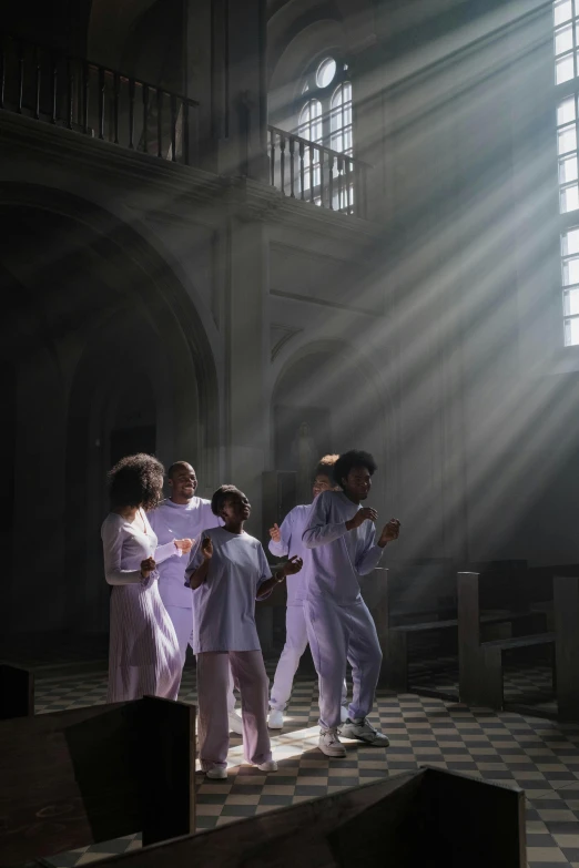 three woman in purple standing near sunlight shining in an old building