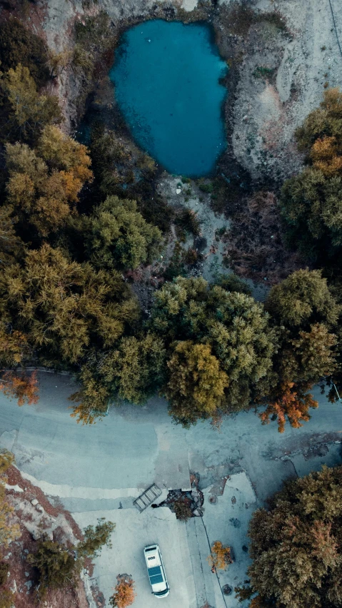 a small white car parked next to a body of water