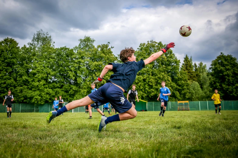 a player is diving for the ball during a soccer game