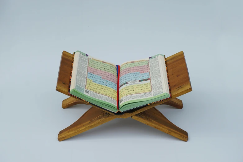 an open book is sitting on top of a wooden stand