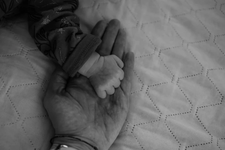 an elderly woman's hands holding a baby shoe