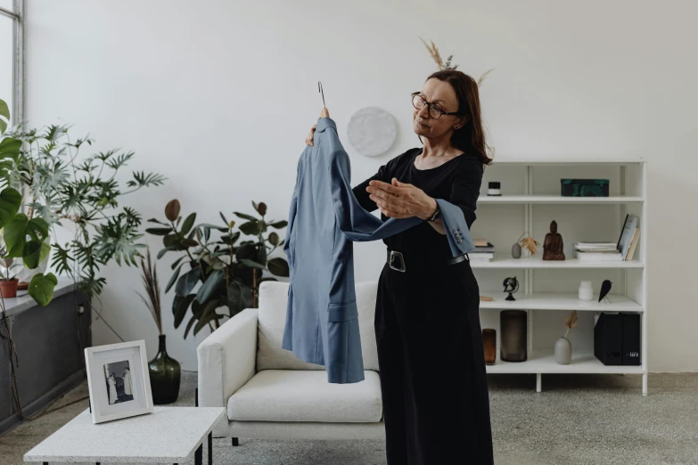 a woman looking at clothing on a rack and a chair