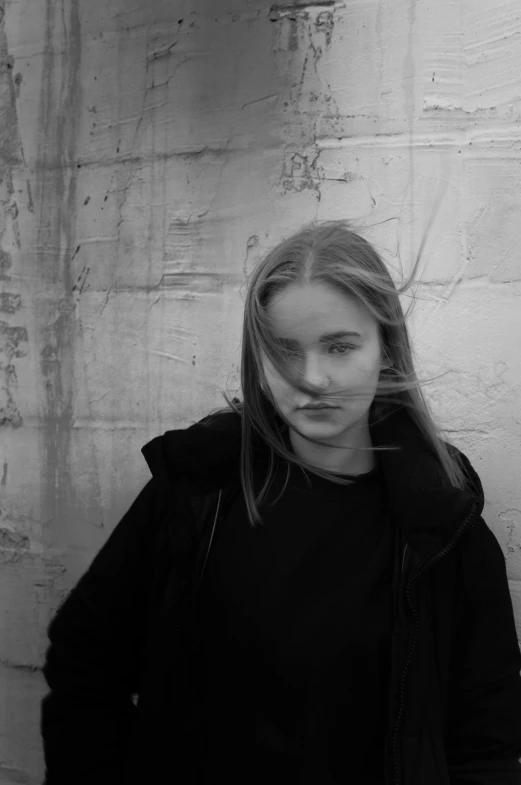 a woman is standing in front of a wall