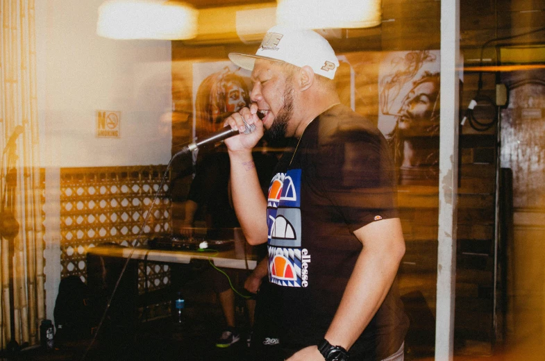 a man standing in front of a music stage while holding a microphone