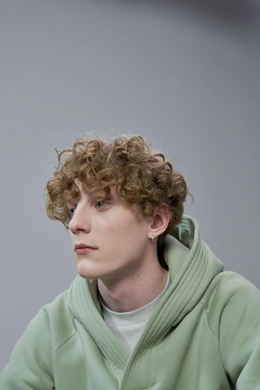 the young man is looking straight ahead with curly hair