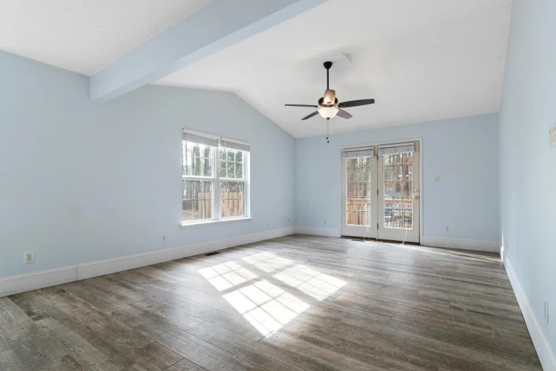 a bedroom has a hard wood floor and a fan