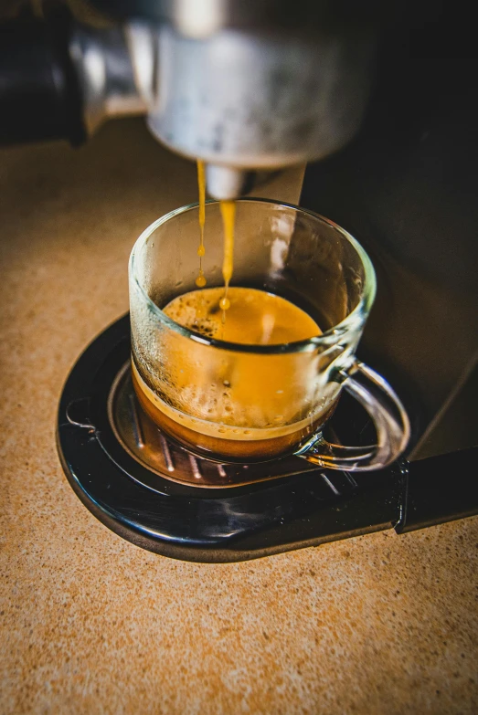 a glass coffee cup on a plate being filled