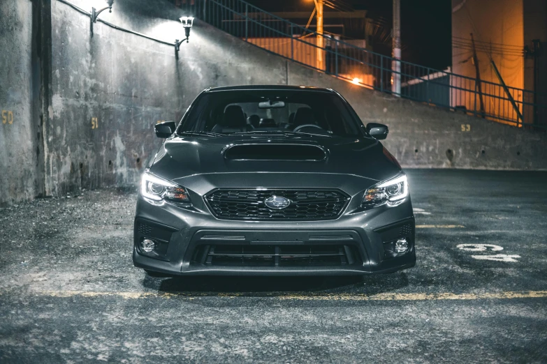 the front view of a grey car parked in a parking lot