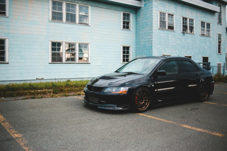 a black car parked in front of a blue building