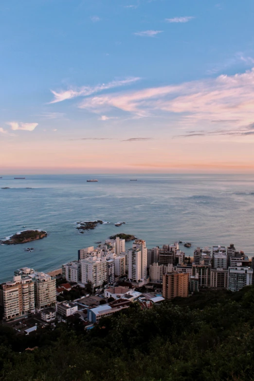 a view of the ocean and a city on a hill above