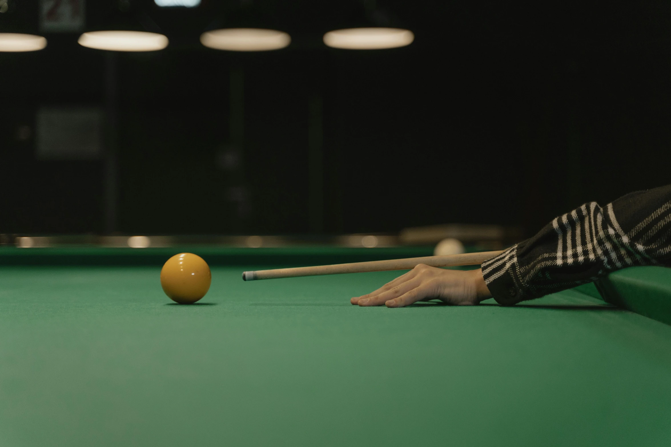 a man placing an object on the pool table