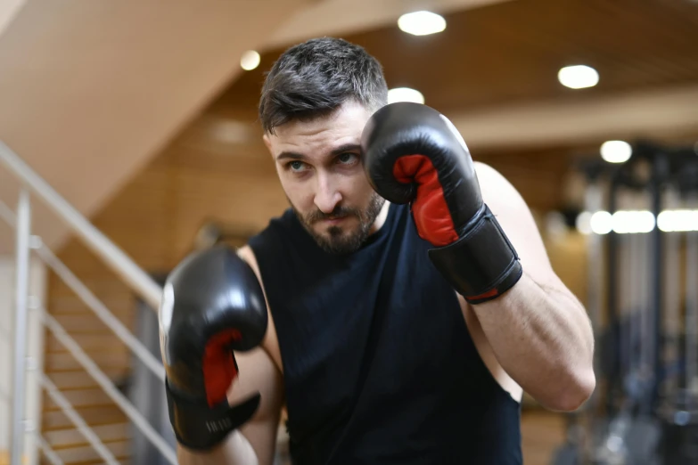 a man wearing boxing gloves in a gym