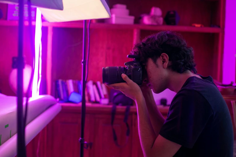 a man holding a camera while looking into a room with some shelves