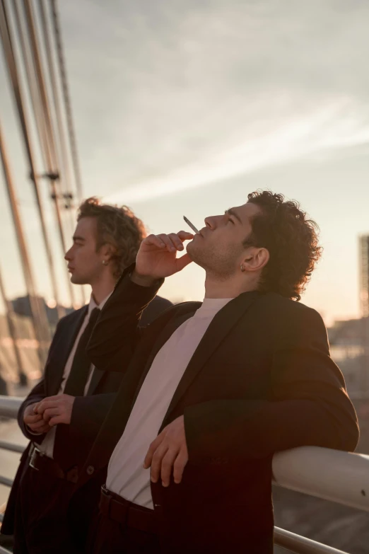 two men smoking cigarettes on the deck of a ship