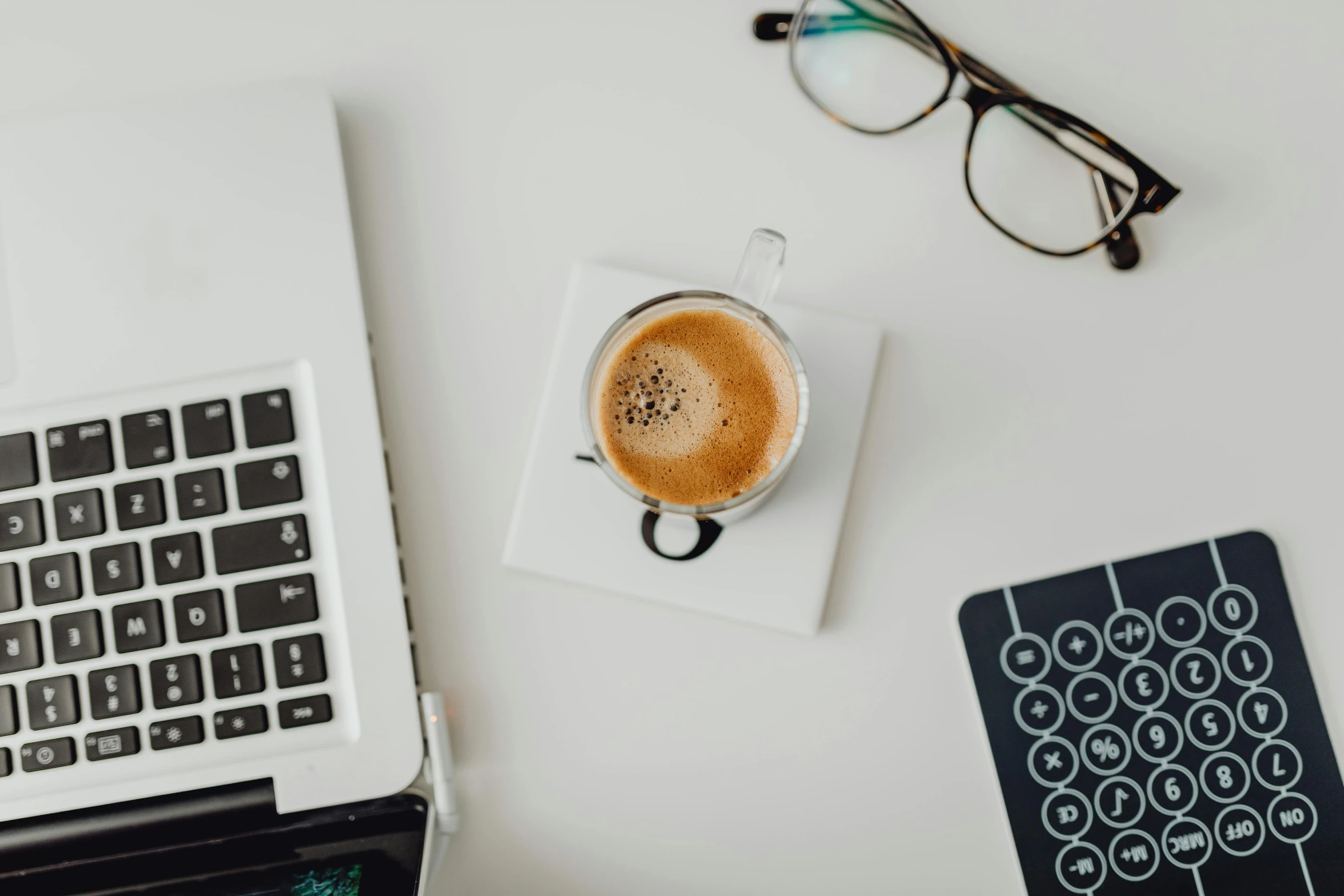 a table that has coffee, eyeglasses on it