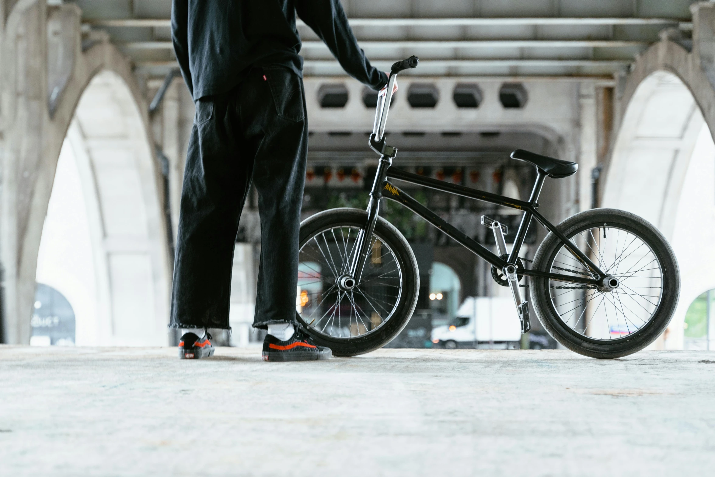 the person in black suit is holding a bike