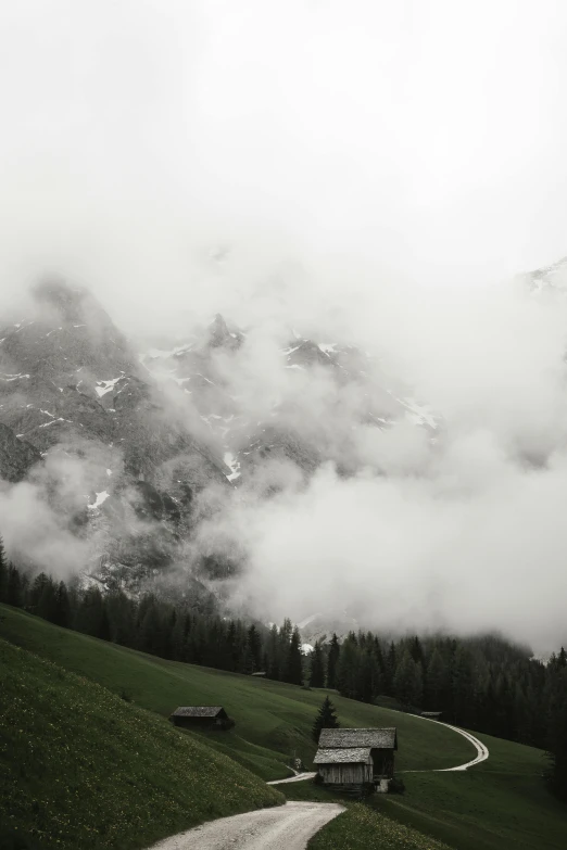 a winding road and mountain covered in fog