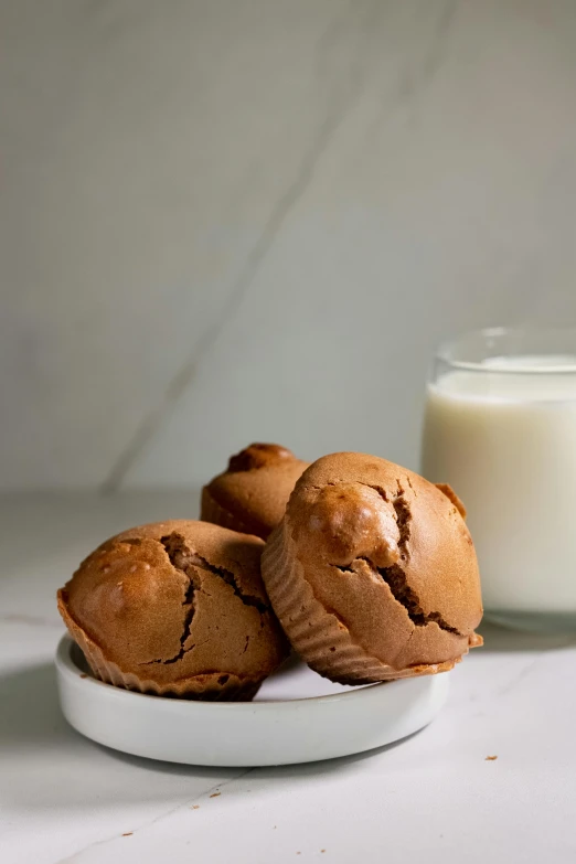 three chocolate muffins with a glass of milk