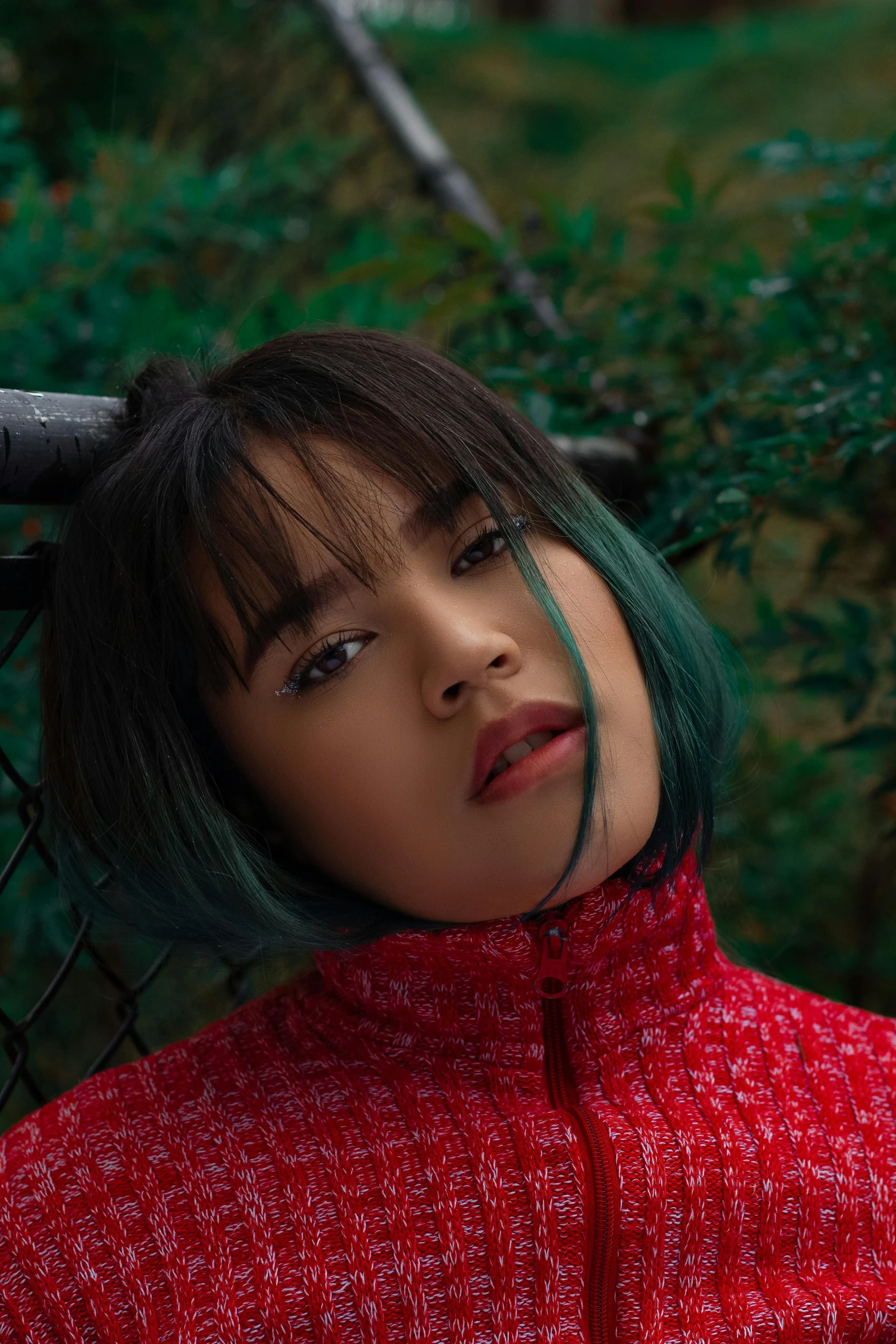 a woman in a red coat looking up with a green spot on her eyes