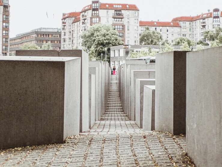 a cement wall and pathway with building in the background